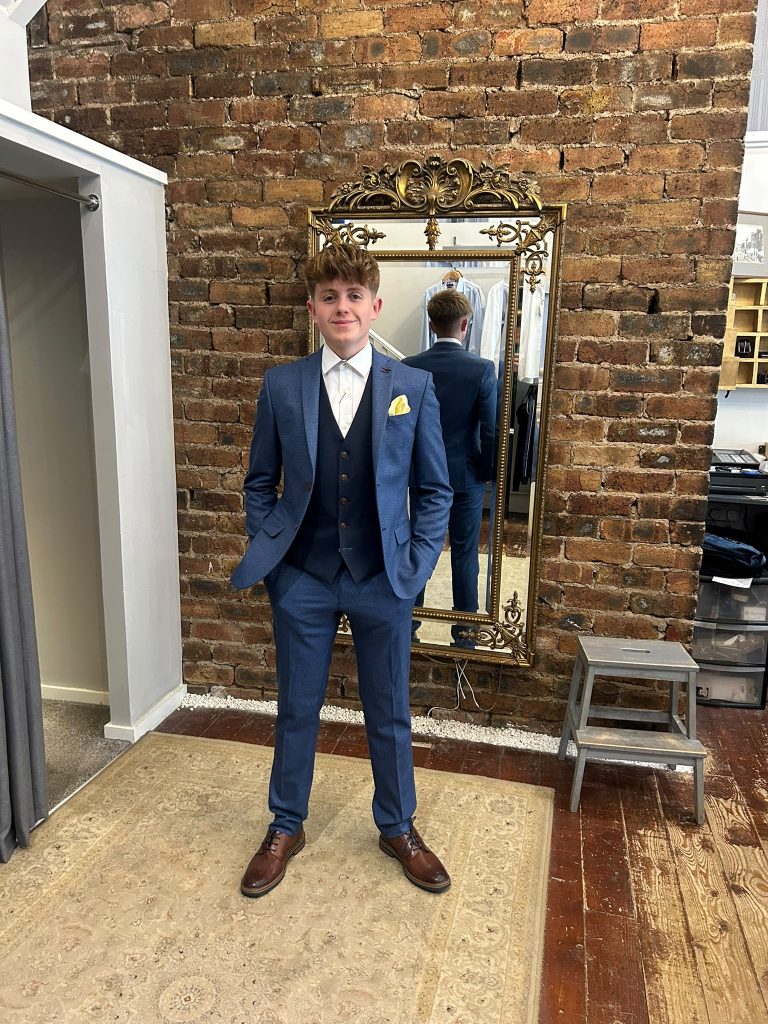 Customer wearing a blue suit with a yellow pocket square.